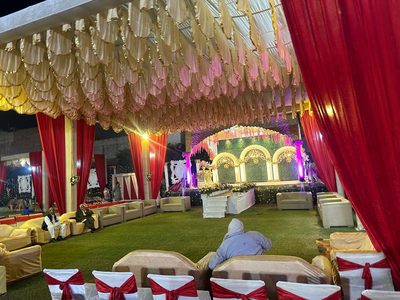 Lawn sofa seating under a draped canopy facing the wedding stage at Dharam Vatika, Sohna Gurgaon
